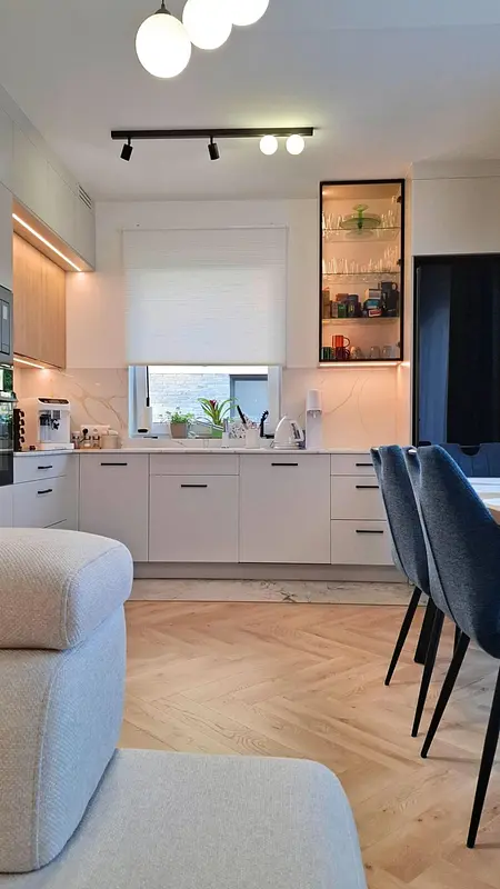 Wnętrze nowoczesnej kuchni skandynawskiej z białymi meblami i drewnianymi akcentami.