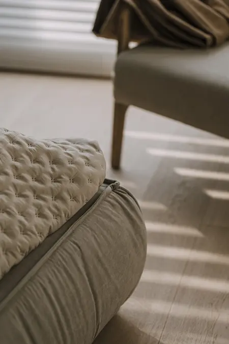 Wnętrze z beżowym fotelem i poduszką w stylu minimaluxe, nowoczesnym, quiet luxury, współczesnym.