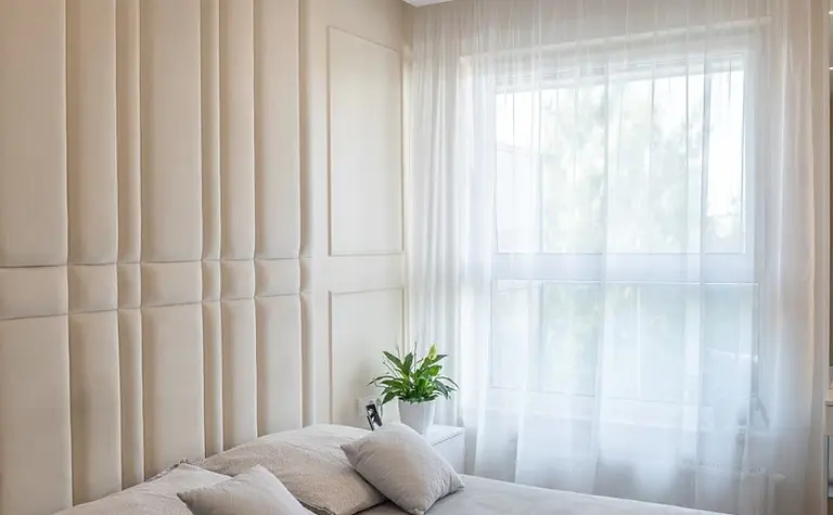 Wnętrze sypialni z jasnymi ścianami, nowoczesnym łóżkiem i rośliną. Styl art deco, quiet luxury, tradycyjny.