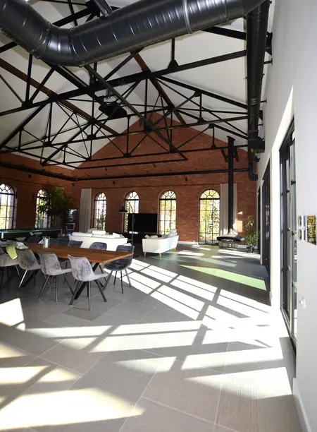 Wnętrze industrialne z minimalistycznymi meblami i dużymi oknami. Styl współczesny.