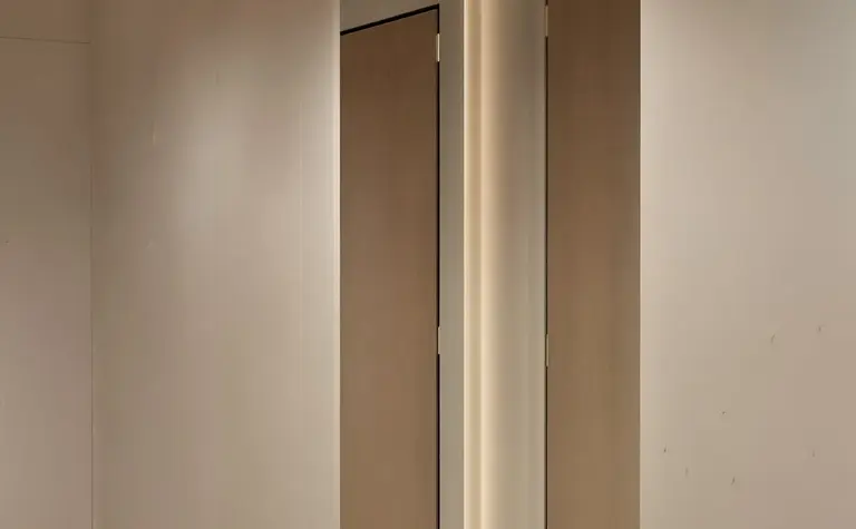 Nowoczesny przedpokój z jasnymi ścianami i drewnianymi drzwiami, styl japandi.