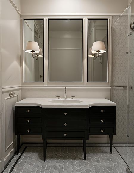 Stylowa łazienka w stylu art deco i vintage z czarną szafką i heksagonalnym podłogą.