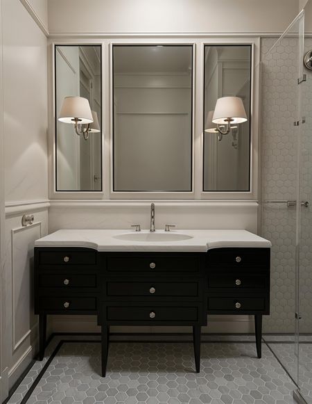 Stylowa łazienka w stylu art deco i vintage z czarną szafką i heksagonalnym podłogą.