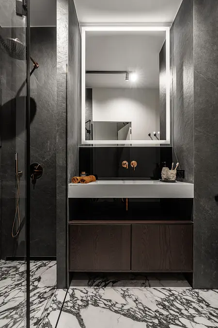 Współczesna łazienka z marmurową podłogą i ciemnymi ścianami