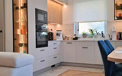 Kuchnia w stylu nowoczesnym i skandynawskim z jasnymi meblami i drewnianymi detalami.