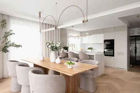Wnętrze jadalni z drewnianym stołem i szarymi krzesłami, nowoczesny design.