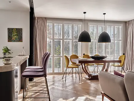 Wnętrze jadalni w stylu art deco i japandi z drewnianym stołem i żółtymi krzesłami.