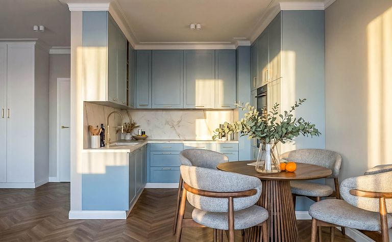 Współczesna kuchnia z niebieskimi meblami i drewnianym stołem