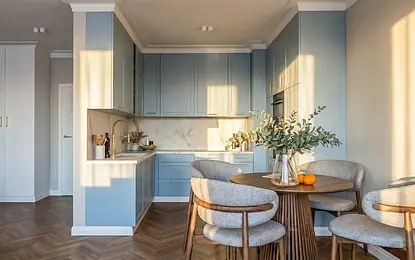 Współczesna kuchnia z niebieskimi meblami i drewnianym stołem