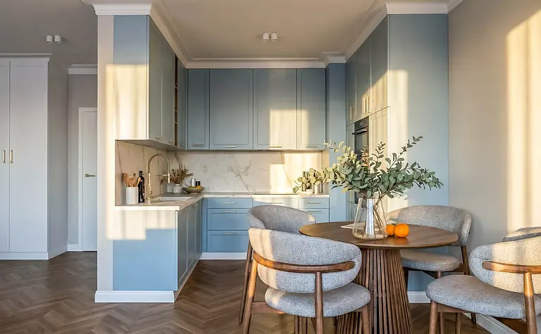 Współczesna kuchnia z niebieskimi meblami i drewnianym stołem