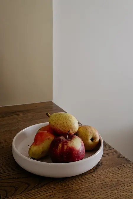 Kompozycja owoców w minimalistycznym wnętrzu, nowoczesne akcenty, skandynawski styl.
