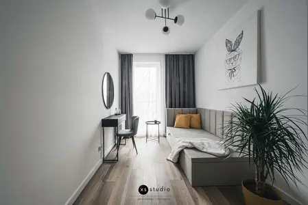 Wnętrze pokoju w stylu japandi z minimalistycznym narożnikiem i rośliną.