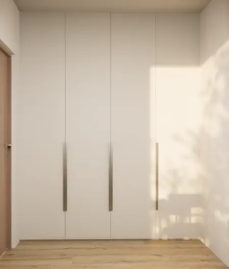 Garderoba w stylu japandi z minimalistycznymi białymi szafami i drewnianą podłogą.