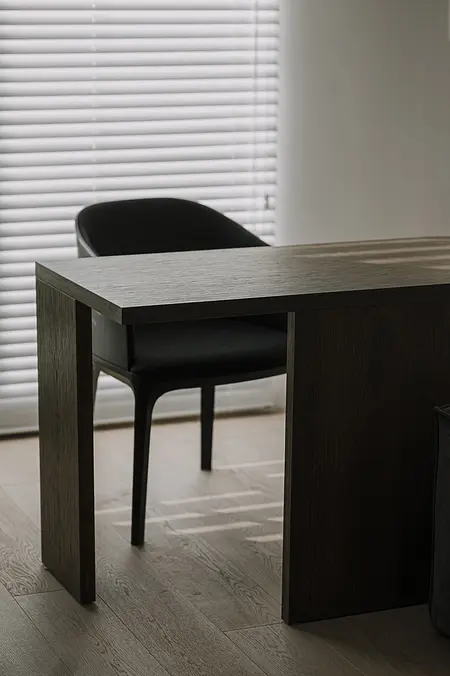 Wnętrze gabinetu z nowoczesnym biurkiem i czarnym krzesłem, styl minimaluxe.