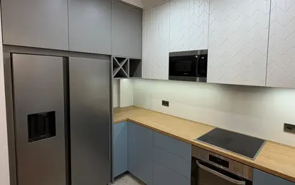 Kuchnia w stylu japandi z szarymi meblami i drewnianym blatem, minimalistyczne akcenty