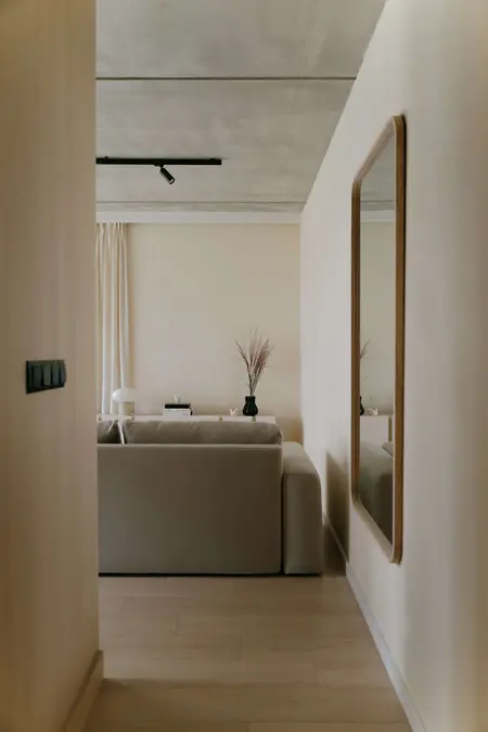 Wnętrze salonu w stylu industrialnym, japandi i skandynawskim z beżową sofą.
