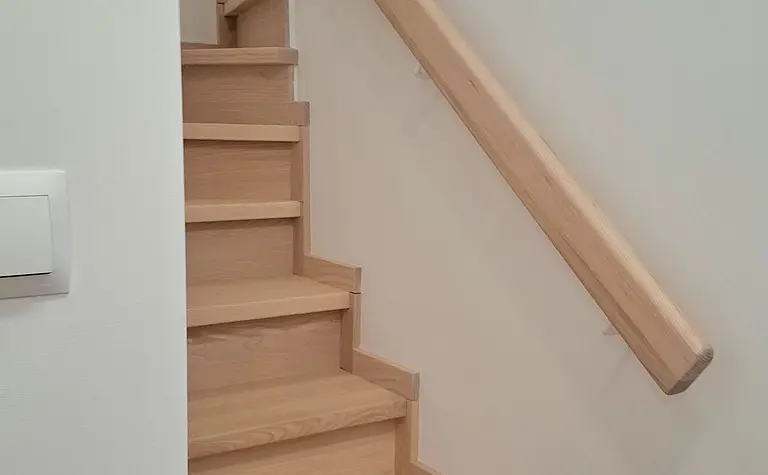 Schody z jasnego drewna w nowoczesnym i skandynawskim wnętrzu