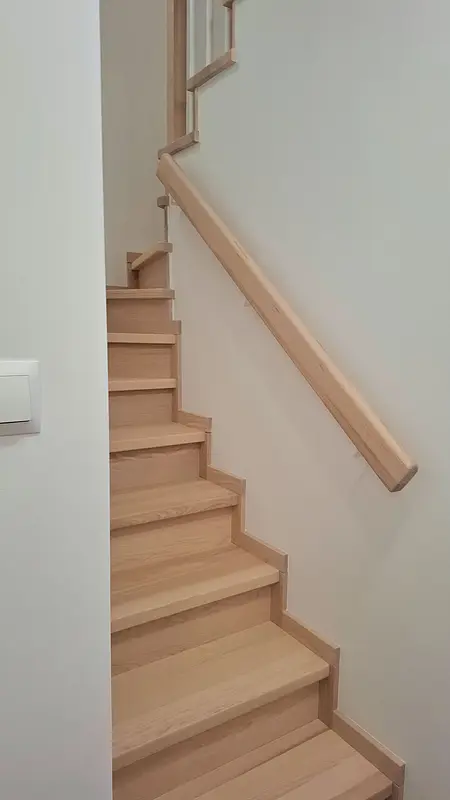 Schody z jasnego drewna w nowoczesnym i skandynawskim wnętrzu