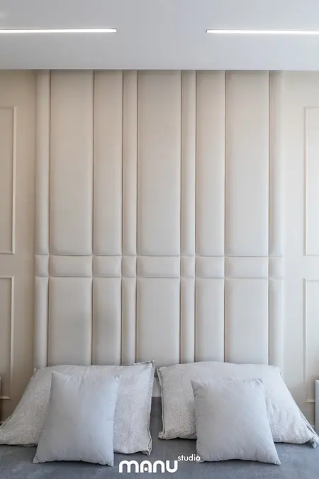 Wnętrze sypialni z beżowym zagłówkiem, szarymi poduszkami, styl art deco, nowoczesny, quiet luxury.
