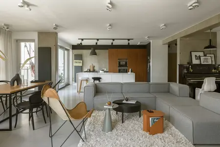 Wnętrze salonu w stylach boho, industrialnym i nowoczesnym z szarym narożnikiem.