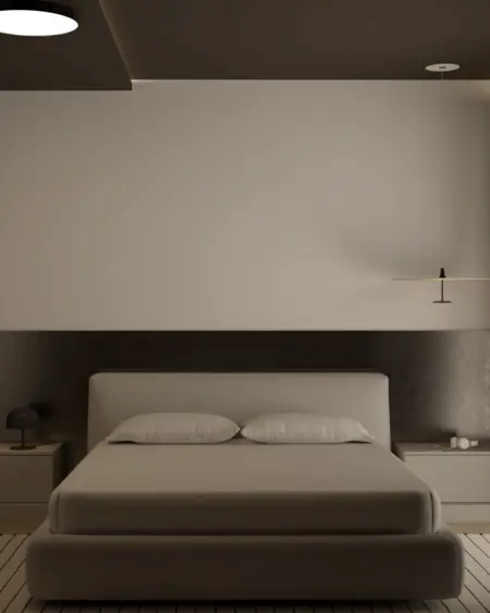 Minimalistyczna sypialnia z szarym łóżkiem i lampą.