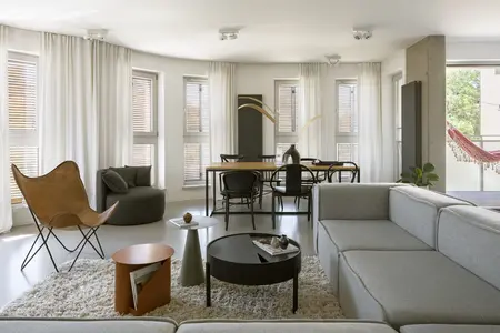 Nowoczesne wnętrze salonu w stylu boho, eklektycznym, industrialnym z szarym narożnikiem.