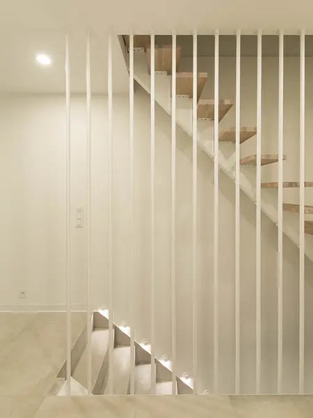 Nowoczesne schody minimalistyczne z drewnem i białymi balustradami.