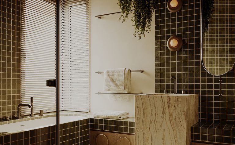 Wnętrze łazienki z ciemnymi płytkami, drewnianym blatem, minimalistycznym i vintage designem.