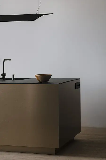 Wnętrze kuchni z brązową wyspą i czarnymi detalami, styl minimaluxe, nowoczesny.