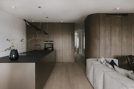 Wnętrze kuchni w stylu minimaluxe z drewnianymi meblami i nowoczesnym oświetleniem.