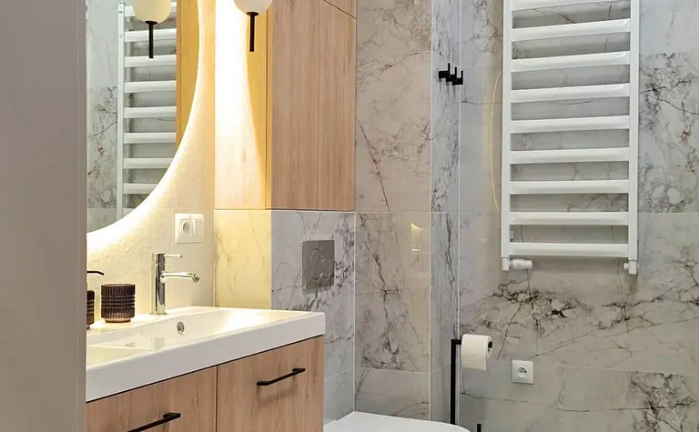 Nowoczesna łazienka z drewnianymi meblami i marmurowymi ścianami
