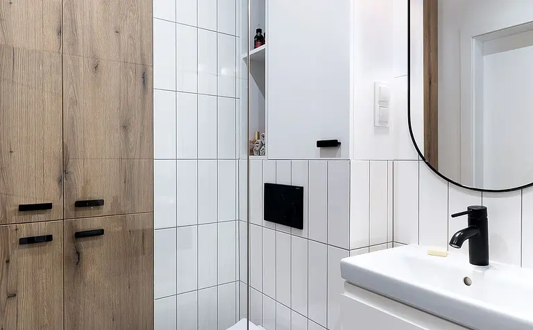 Wnętrze jadalni z drewnianym stołem, niebieską sofą i roślinami. Styl glamour, industrialny, minimalistyczny.
