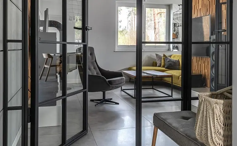 Przedpokój w stylu industrialnym i minimalistycznym z szarymi płytkami i drewnianymi akcentami.