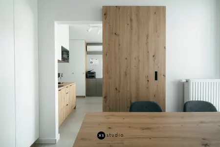 Minimalistyczna jadalnia z drewnianymi meblami, skandynawskie detale i współczesne wykończenia.