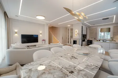 Wnętrze salonu z jasnymi meblami, eleganckim stołem, w stylu art deco, eklektycznym i współczesnym.