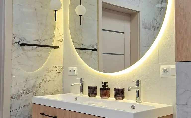 Nowoczesna łazienka w stylu skandynawskim z drewnianą szafką i dużym lustrem.