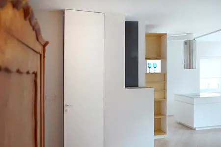 Wnętrze minimalistyczne z białymi meblami i drewnianymi detalami.