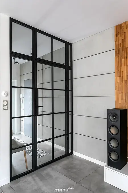 Przedpokój w stylu industrialnym z minimalistycznym designem, betonowe ściany, drewniane akcenty.