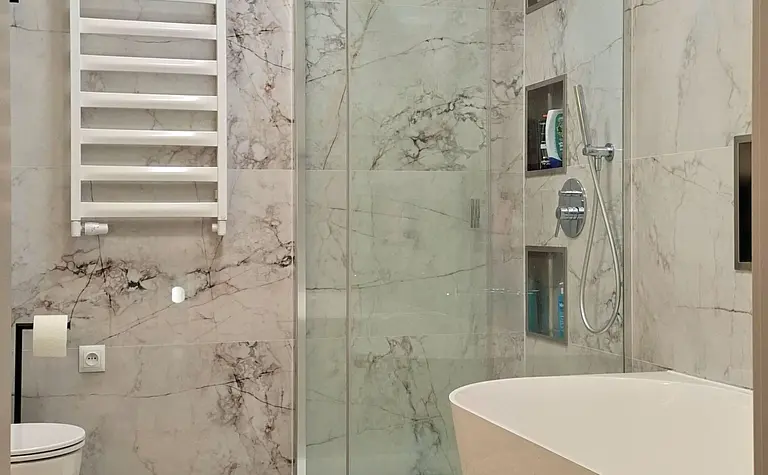 Nowoczesna łazienka z wanną, prysznicem i marmurowymi płytkami.