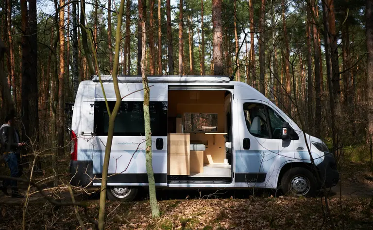 Van w lesie z minimalistycznym wnętrzem i współczesnym designem.