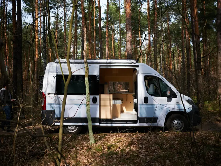 Van w lesie z minimalistycznym wnętrzem i współczesnym designem.