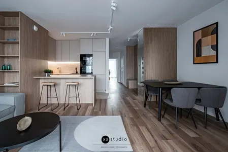 Wnętrze kuchni w stylu japandi z drewnianymi meblami i minimalistycznym oświetleniem.
