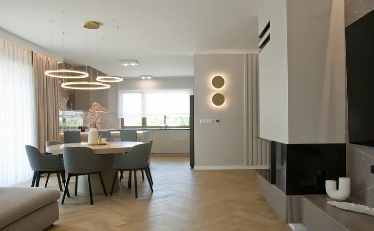 Jadalnia z okrągłym stolikiem, szarymi krzesłami, minimalistyczny styl, nowoczesny design.