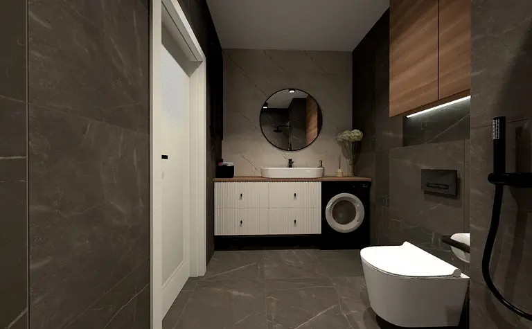 Współczesna łazienka z szarymi płytkami, drewnianym blatem i okrągłym lustrem.