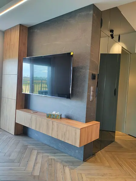 Nowoczesne wnętrze salonu z telewizorem i drewnianymi meblami, współczesny wystrój.