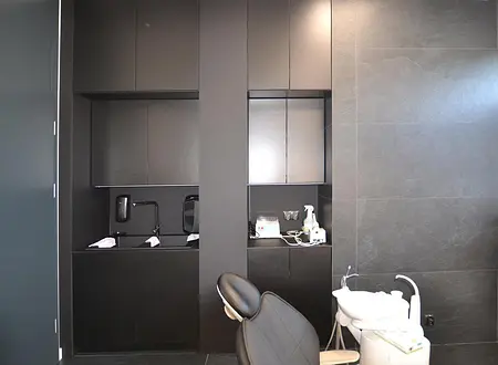 Nowoczesne wnętrze biura w minimalistycznym stylu z czarnymi meblami i szarymi ścianami.