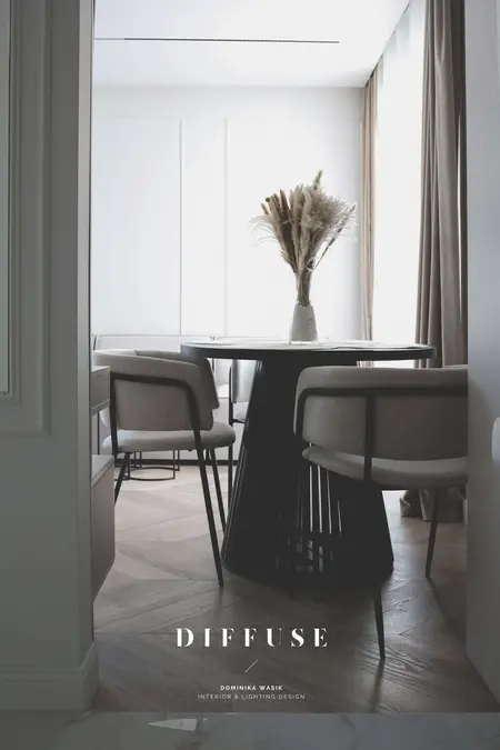 Jadalnia w stylu boho i minimalistycznym z okrągłym stołem i szarymi krzesłami.