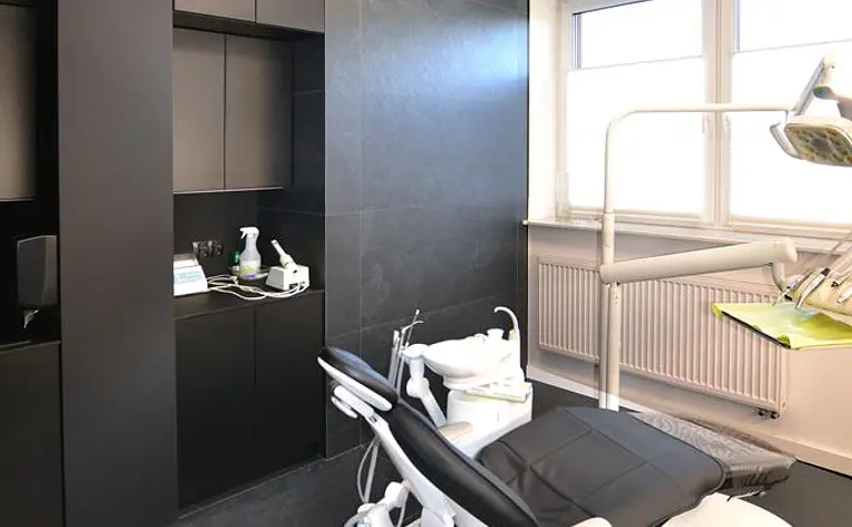 Gabinet z nowoczesnym fotelem dentystycznym i minimalistycznymi meblami.
