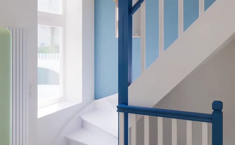 Nowoczesny korytarz z niebieską balustradą i żółtym sufitem w stylu dopamine decor.