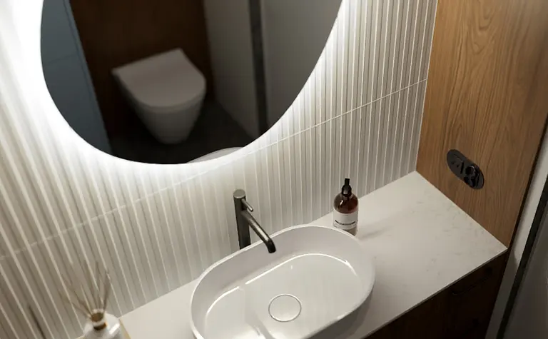 Współczesna łazienka z białą umywalką i drewnianymi detalami.